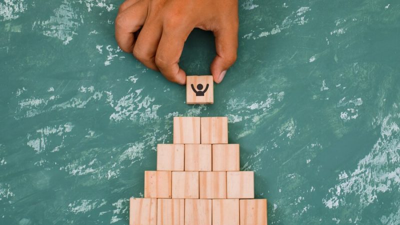 hand-putting-stacking-wooden-cubes_176474-7083